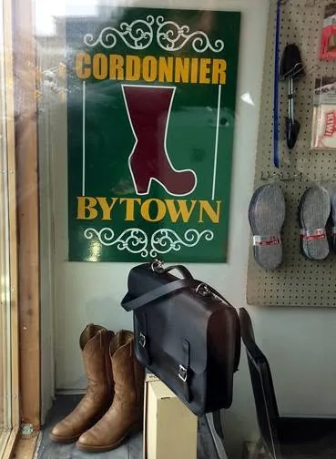 Shop window with the 'Cordonnier Bytown' sign and boots ready for pickup